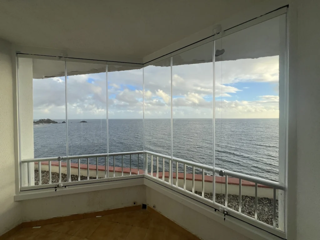 Terraza con vistas al mar en Almuñécar cerrada con cortinas de cristal abatibles de Instalaciones Baena