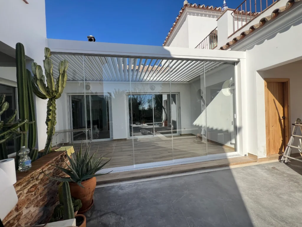 Instalación de cortinas de cristal correderas y pérgola bioclimática blanca en chalet de Lantejuela, Sevilla.